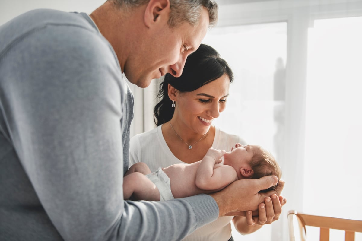 Familia sosteniendo a su recién nacido envuelto en una cobija